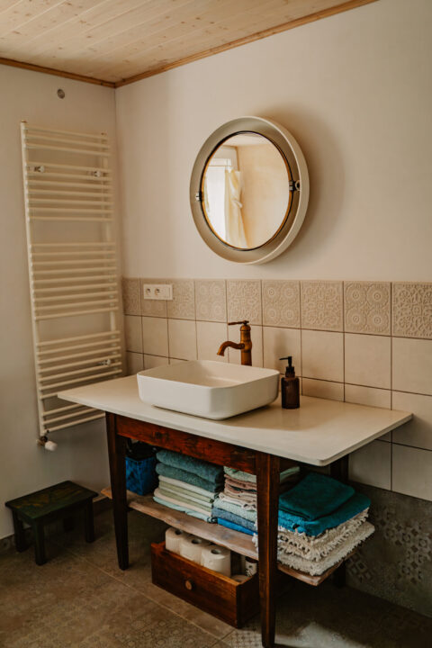 Rustykalna łazienka z lustrem i umywalką