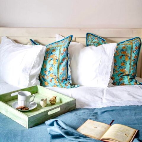 Łóżko z poduszkami i tacą z herbatą