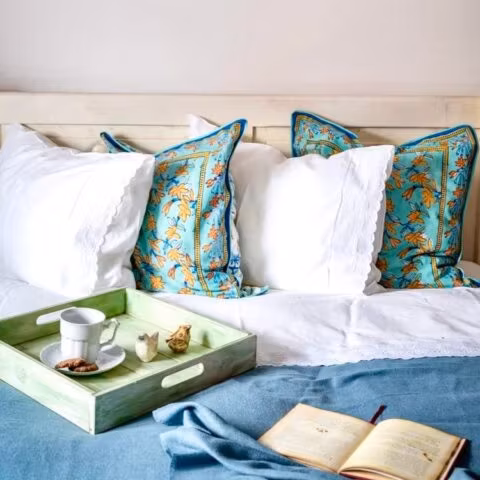 Łóżko z poduszkami i tacą z herbatą