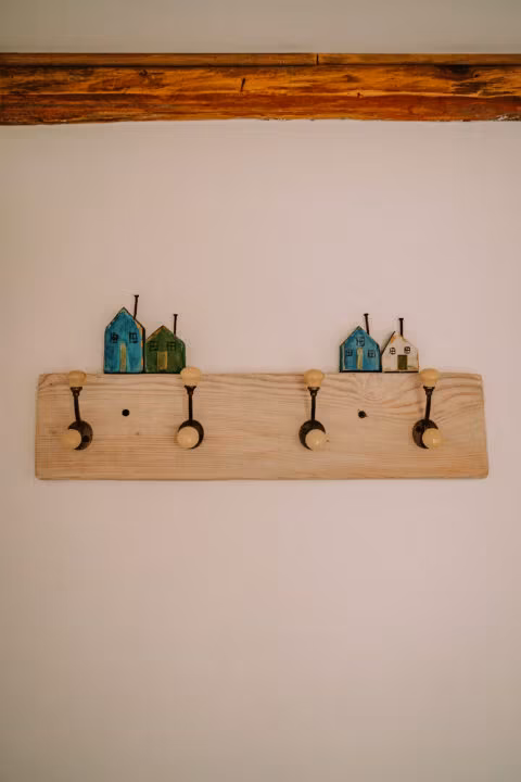 Dekoracyjny wieszak z małymi domkami.