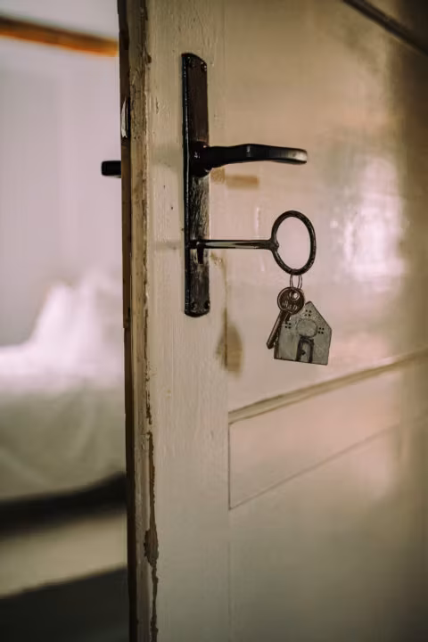 Klucz w drzwiach z zawieszką domku