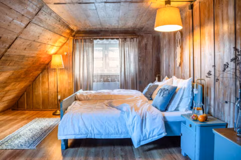 Przytulna sypialnia z drewnianymi ścianami i łóżkiem