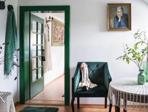 Wnętrze z zielonymi drzwiami i fotelem.