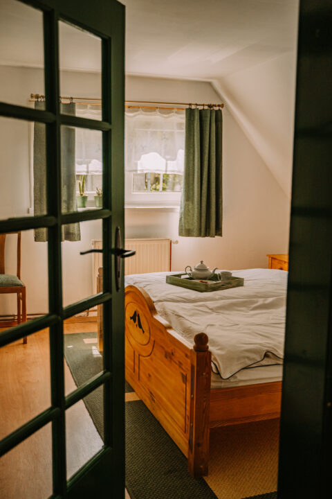 Sypialnia z drewnianym łóżkiem i herbatą na tacy