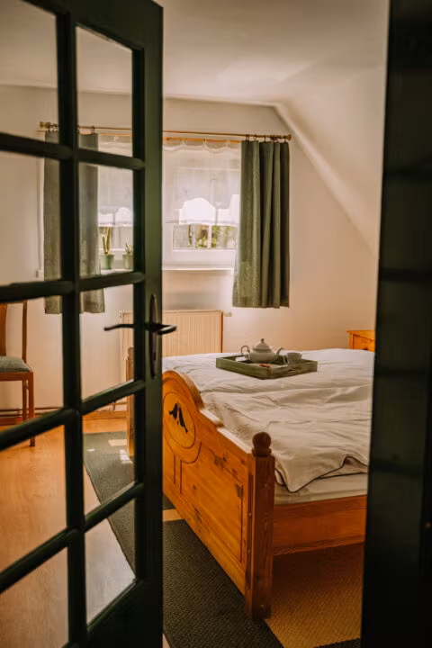 Sypialnia z drewnianym łóżkiem i herbatą na tacy