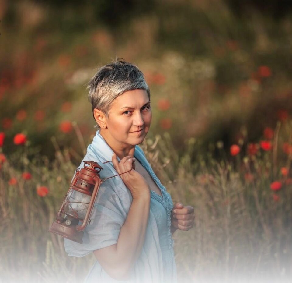 Kobieta z lampą na polu kwiatów