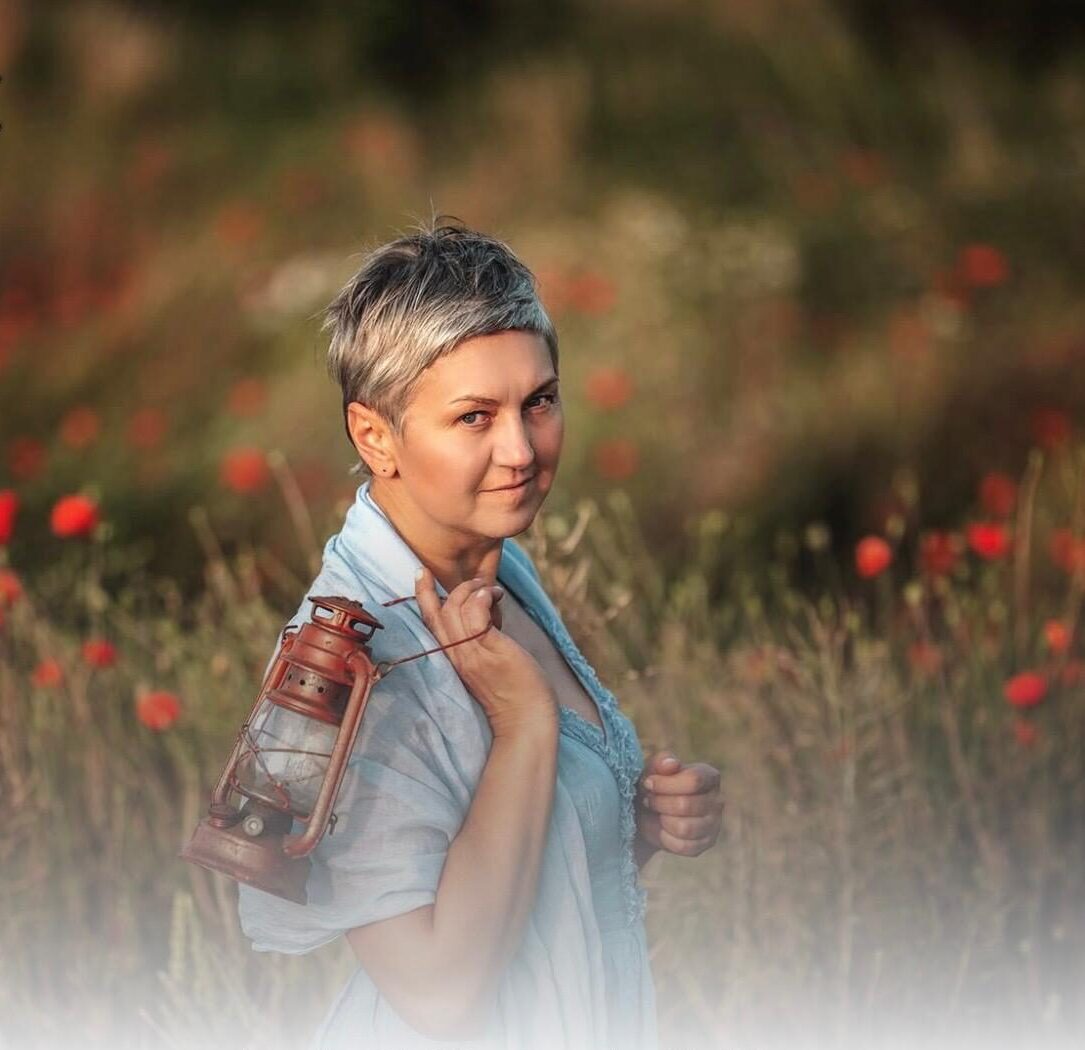 Kobieta z lampą na polu kwiatów